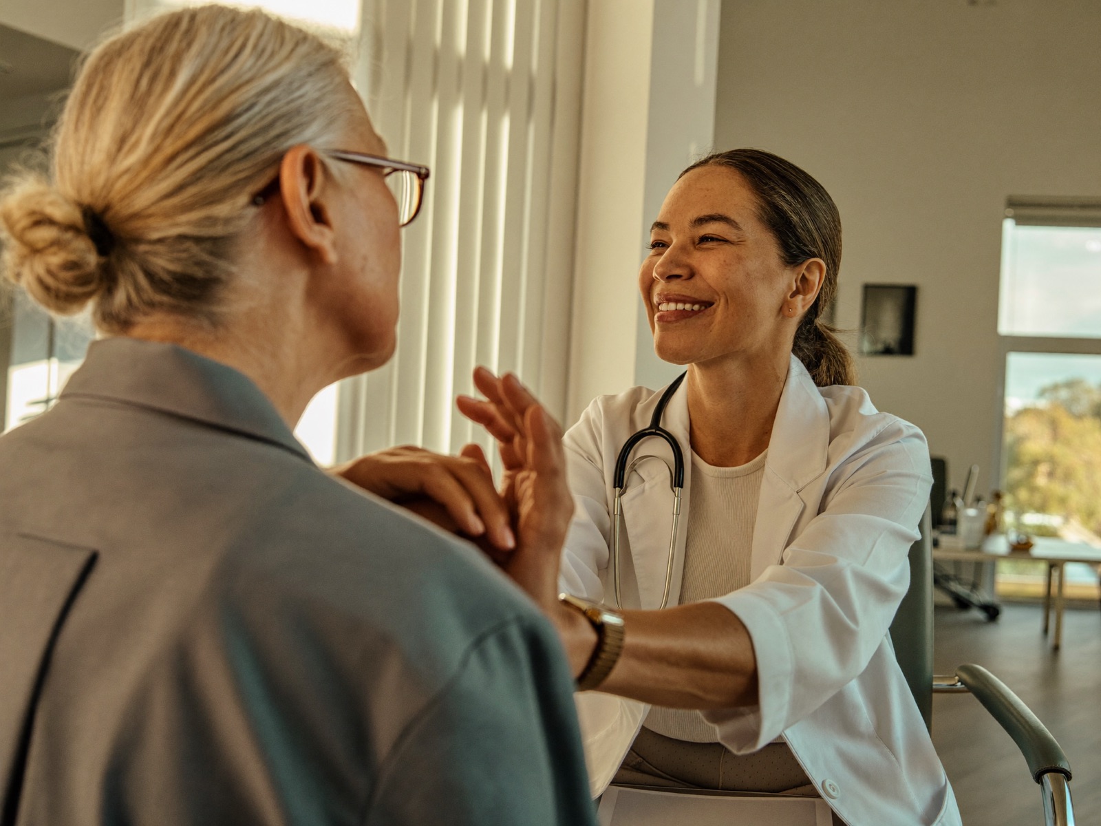 A GP consulting with a patient in a warm, sunlit clinic